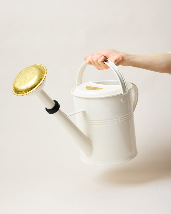 Farmer’s Enameled Watering Can — carrying the White can by its top handle; Farmhouse Pottery