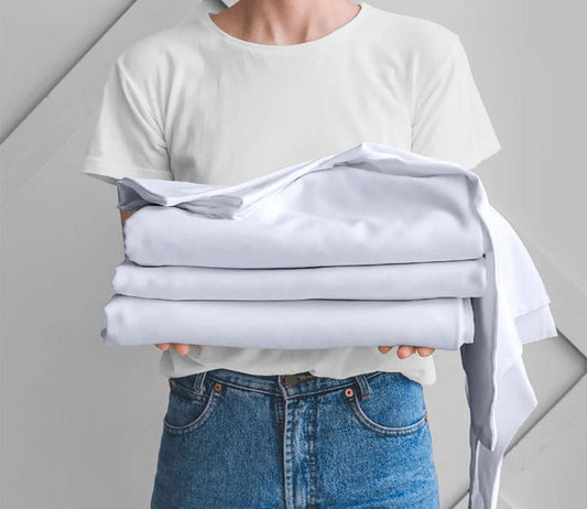 Night Song Sheet Set by City Mattress, model holding white sheets